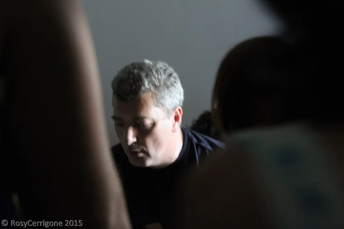 Pino Poclen in penombra, concentrato in ascolto